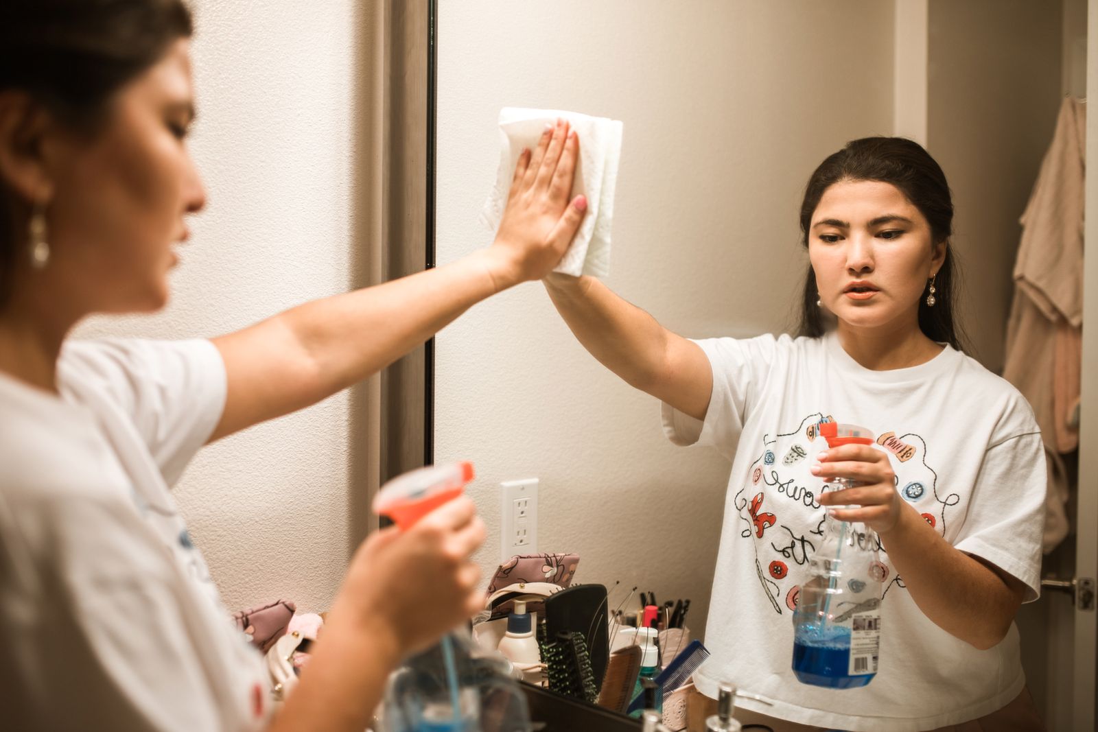 Luxe housekeeper polishing a bathroom mirror
