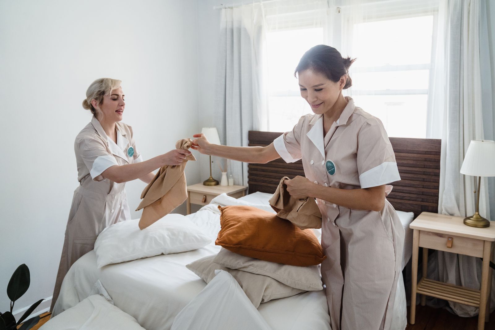 Two Luxe housekeepers preparing a bedroom